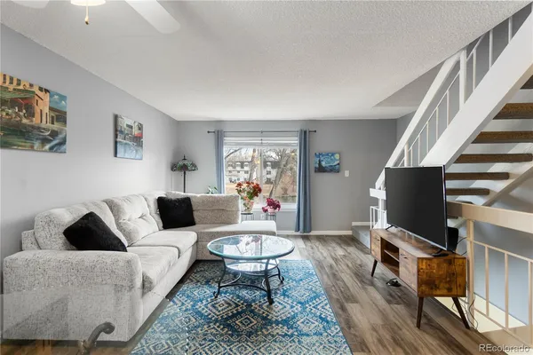 a living room with furniture a rug and a flat screen tv