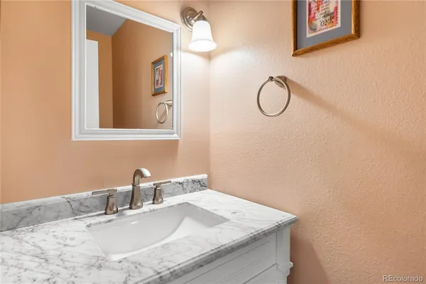 a bathroom with a granite countertop sink and a mirror