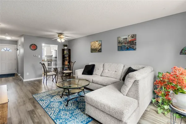 a living room with furniture and a dining table with wooden floor