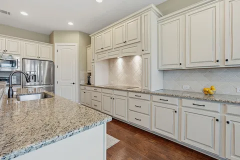 a large kitchen with kitchen island a large counter space a sink and stainless steel appliances
