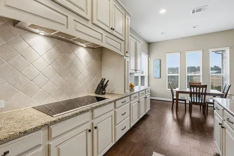 a kitchen with stainless steel appliances a refrigerator a stove a sink dishwasher a oven and a dining table with wooden floor