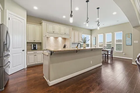 a kitchen with granite countertop wooden floor table and chairs