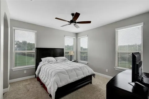 a spacious bedroom with a bed and a flat screen tv