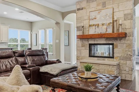 a kitchen with stainless steel appliances granite countertop a refrigerator a oven a sink and white cabinets with wooden floor