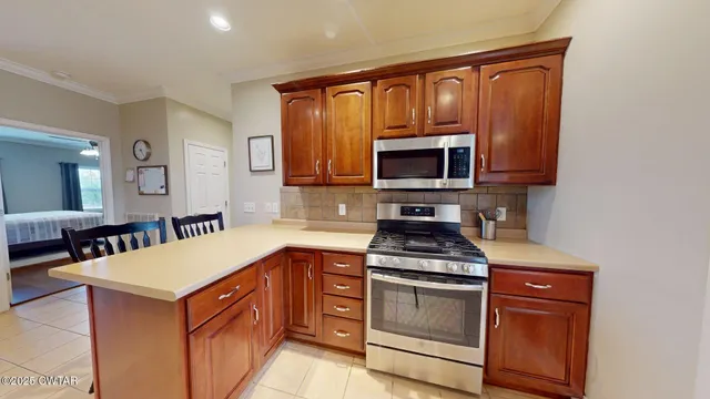 a kitchen with granite countertop a stove top oven microwave and cabinets
