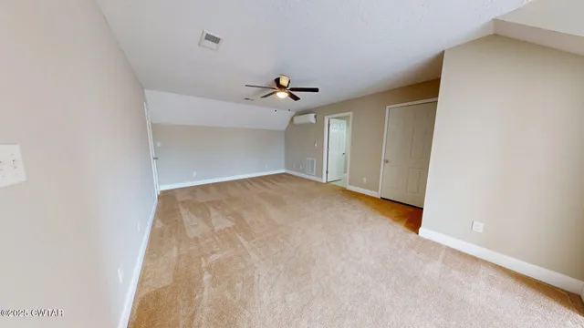 an empty room with a ceiling fan and a window