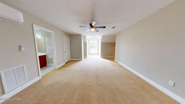 a view of a big room with chandelier fan and windows