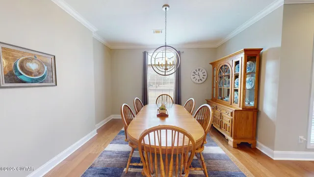 a view of a dining room with furniture wooden floor and a chandelier