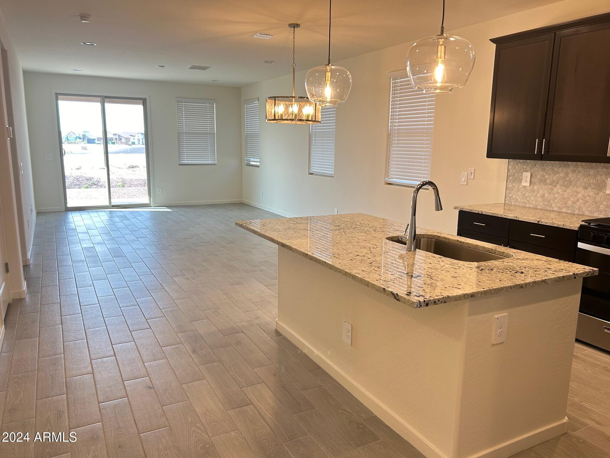 20520 North Candlelight Road Maricopa, AZ 85138 - Photo 4 of 18 a kitchen with kitchen island granite countertop a sink a counter top space and cabinets