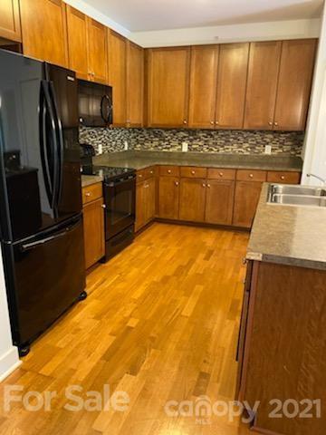 630 Calvert Street, Unit 409 Charlotte, NC 28208 - Photo 4 of 11 a kitchen with stainless steel appliances granite countertop a refrigerator a stove and a sink
