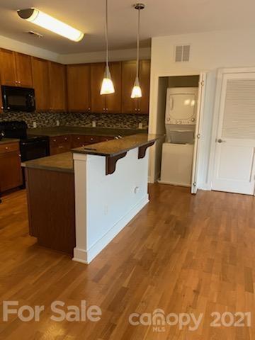 630 Calvert Street, Unit 409 Charlotte, NC 28208 - Photo 5 of 11 a kitchen with stainless steel appliances granite countertop a sink a stove and a refrigerator