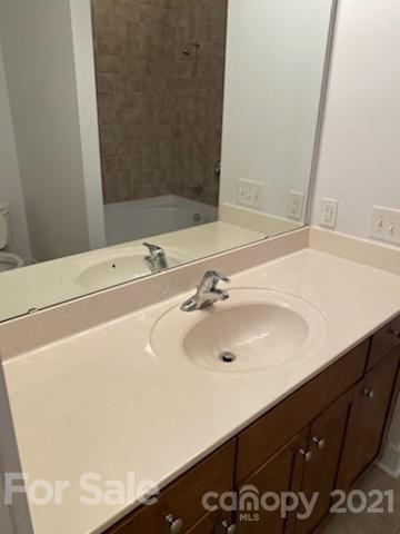 630 Calvert Street, Unit 409 Charlotte, NC 28208 - Photo 10 of 11 a bathroom with a sink and a mirror