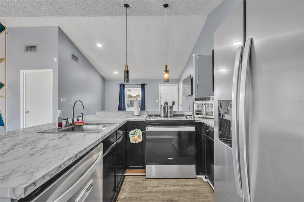 222 West Panama Road Winter Springs, FL 32708 - Photo 10 of 25 a kitchen with stainless steel appliances granite countertop a sink a stove and a refrigerator