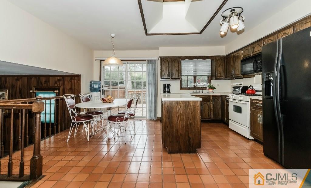 28 Fox Hill Road Edison, NJ 08820 - Photo 9 of 20 a kitchen with stainless steel appliances granite countertop a stove top oven a sink dishwasher a dining table and chairs with wooden floor