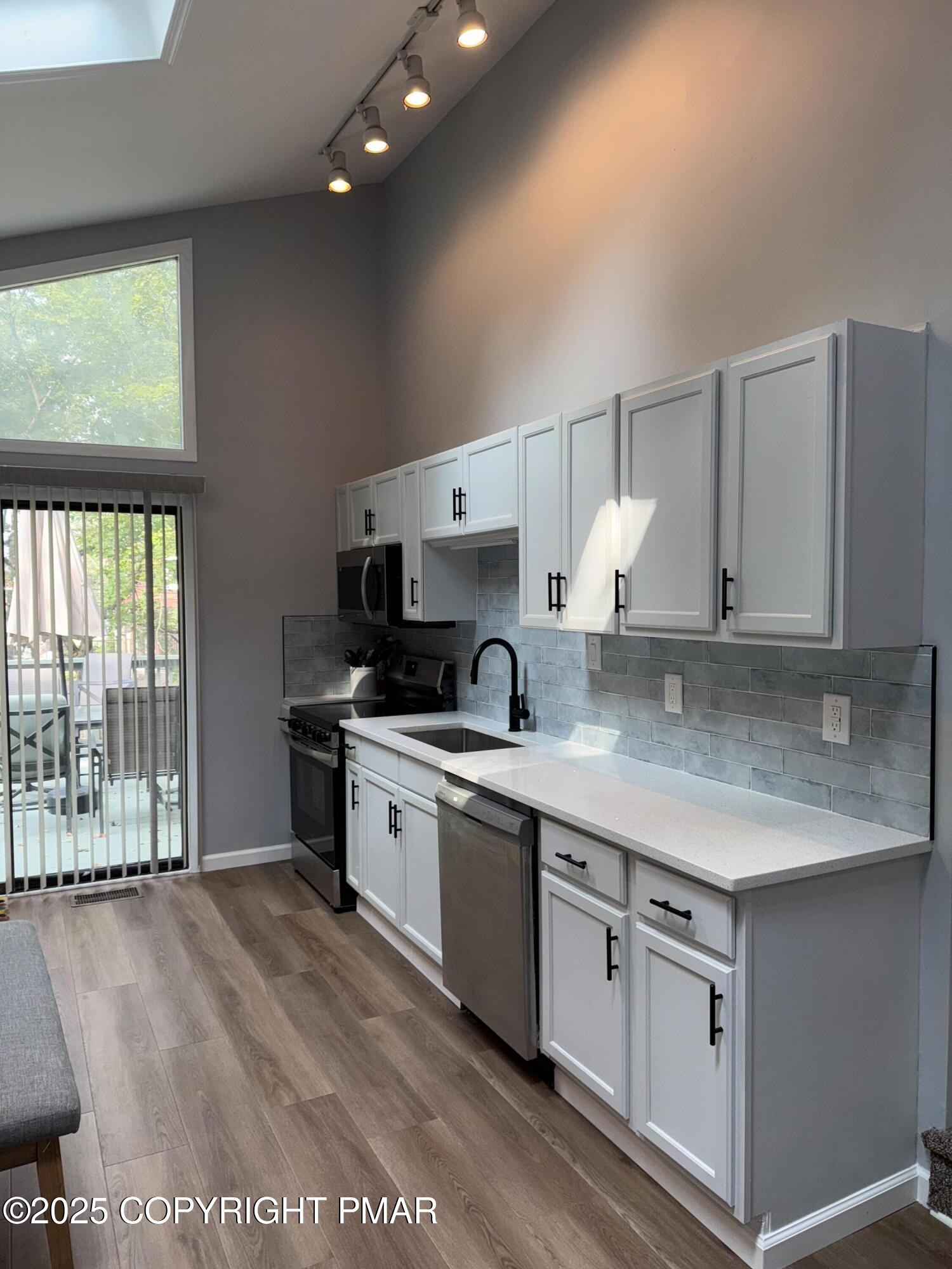 11 Maplewood Road Lake Harmony, PA 18624 - Photo 8 of 44 a open kitchen with stainless steel appliances granite countertop a stove a sink and a granite counter tops with white cabinets next to a window