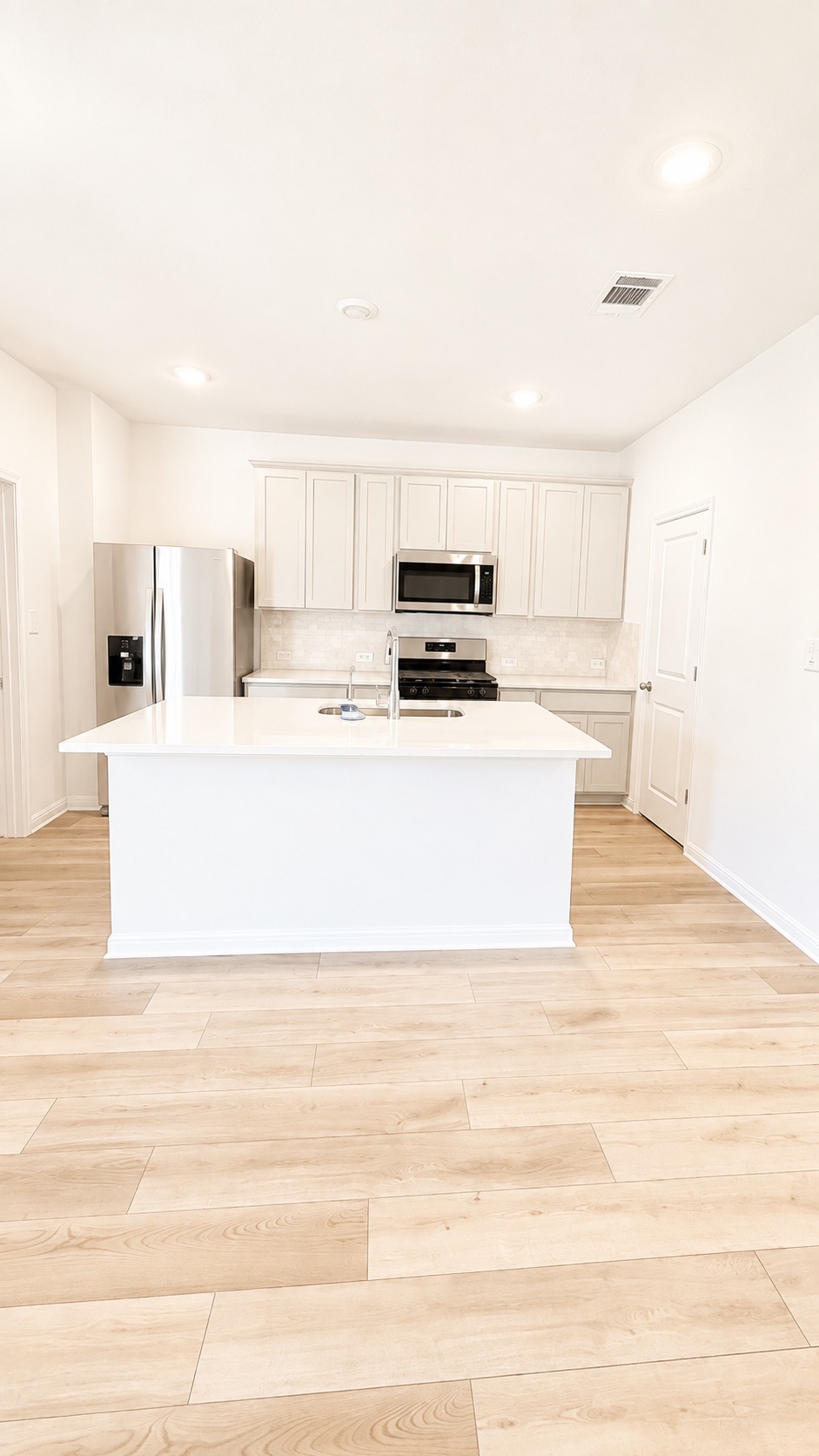 116 Maple Hedge Road Hutto, TX 78634 - Photo 2 of 13 Culinary creations await in this modern kitchen featuring a central island with sink and stainless steel appliances.