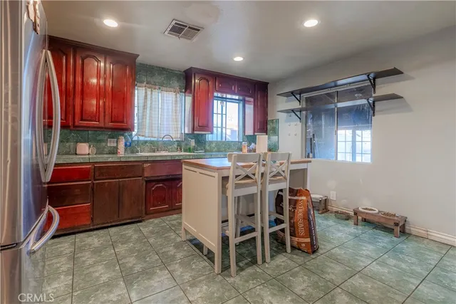 a open kitchen with stainless steel appliances granite countertop a stove a sink and a refrigerator