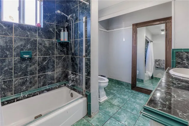 a bathroom with a tub a toilet and a shower