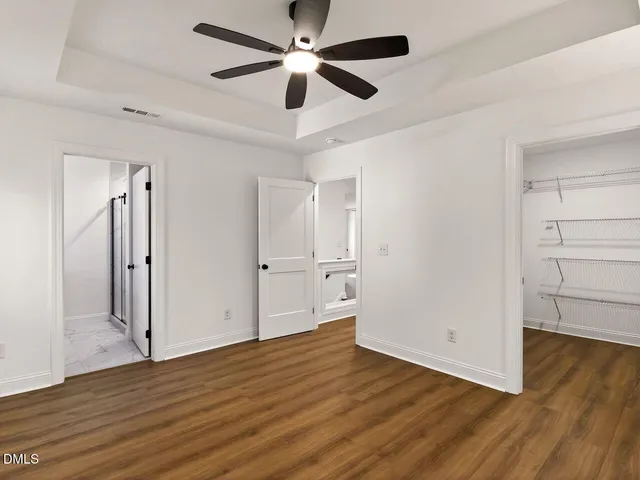 a view of an empty room with wooden floor