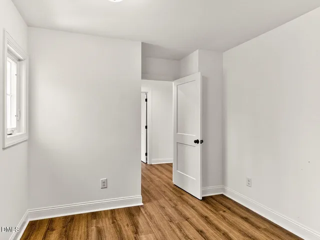 a view of empty room with wooden floor