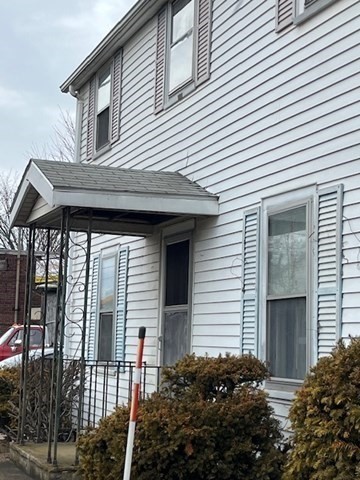 24 Lowell Street Wilmington, MA 01887 - Photo 2 of 26 a brick house with large windows and potted plants