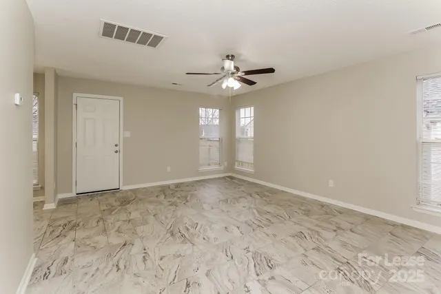 an empty room with a window and a fan
