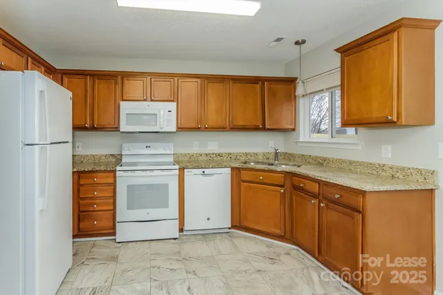 a kitchen with granite countertop a sink stainless steel appliances and cabinets