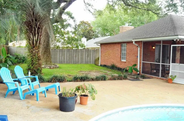 a view of a chair and table in backyard of the house