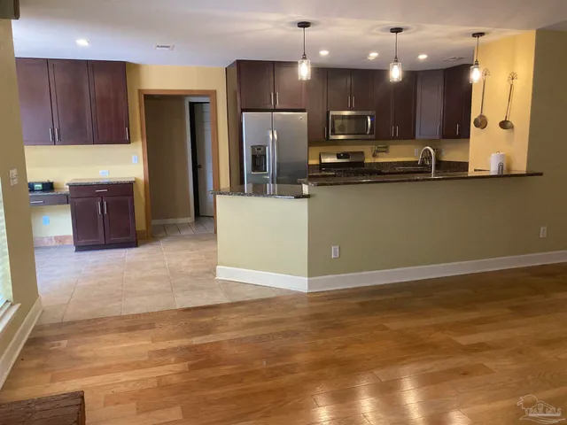 a kitchen with kitchen island granite countertop a stove top oven a sink and a refrigerator