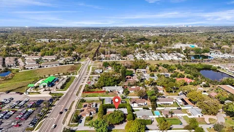 a view of a house with potted plants and a large tree