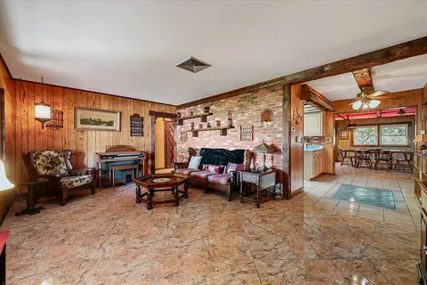 a living room with furniture a fireplace and a large window