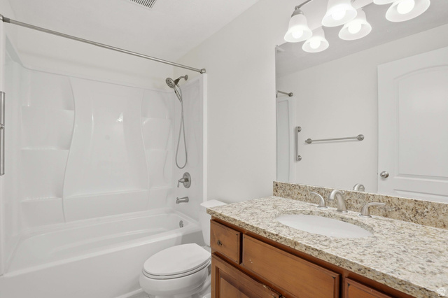 2007 Fielding Hill Lane Draper, UT 84020 - Photo 41 of 83 Bathroom featuring a granite-finish vanity with an undermount sink and brushed nickel faucet, a fiberglass tub/shower combination with a handheld showerhead, and a multi-bulb vanity light fixture