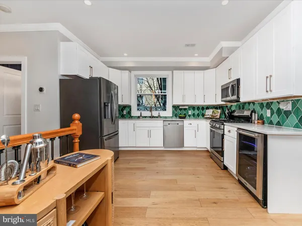 a kitchen with stainless steel appliances granite countertop a stove refrigerator and a sink