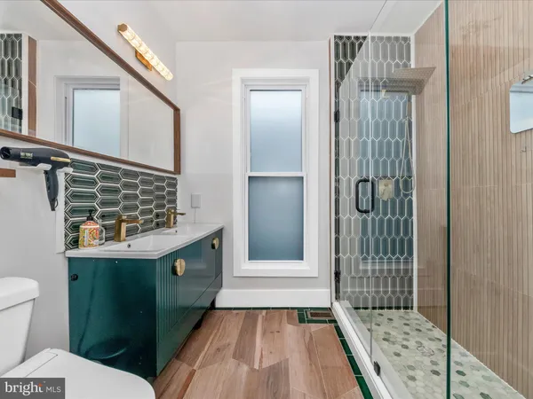 a bathroom with a sink a toilet and shower