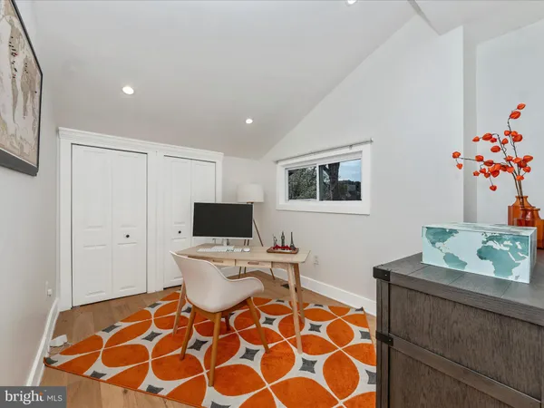 a living room with a black white checkered floor with a gaming machine and dining chair