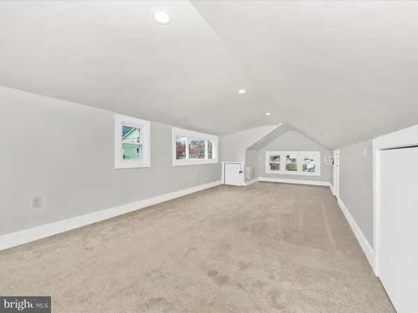 an empty room with white walls and windows