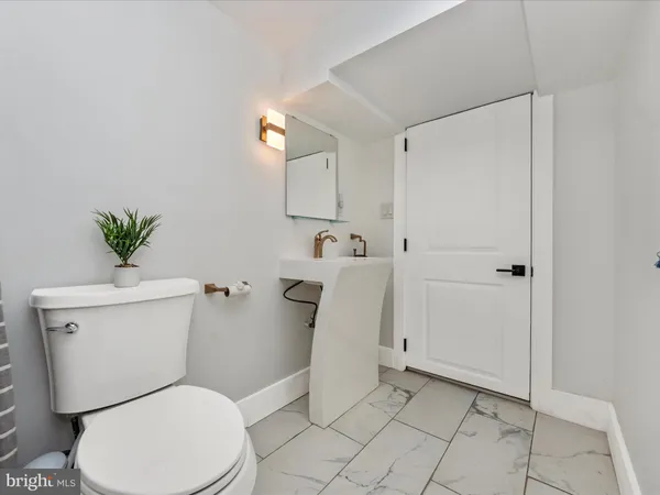 a white toilet sitting next to a bathroom sink