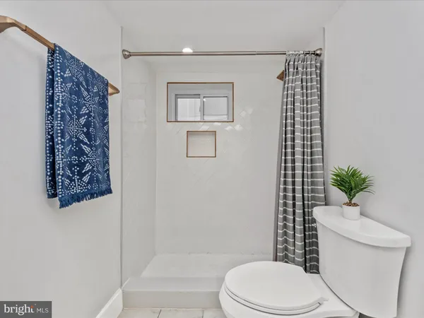 a white toilet sitting next to a shower curtain