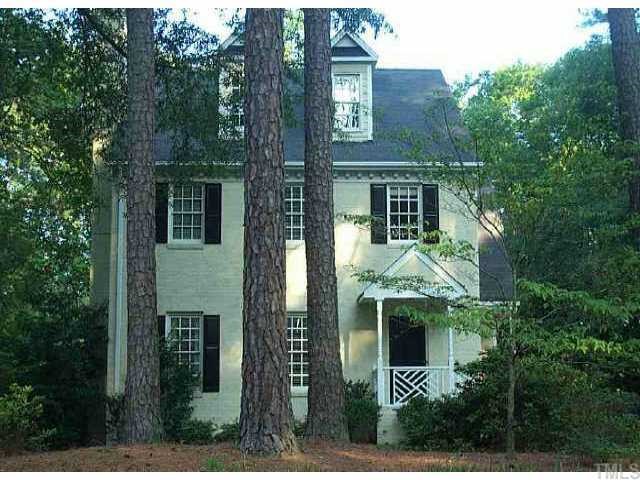 a view of a house with brick walls and a tree