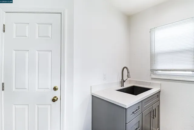 a white kitchen with sink and window