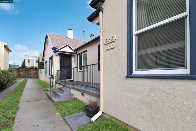 a view of a house with a small yard and wooden floor and fence