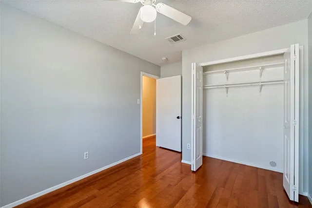 an empty room with wooden floor and closet