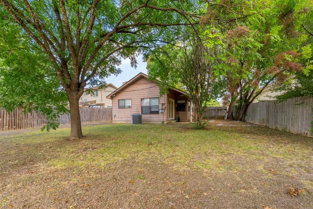 a front view of a house with yard and tree