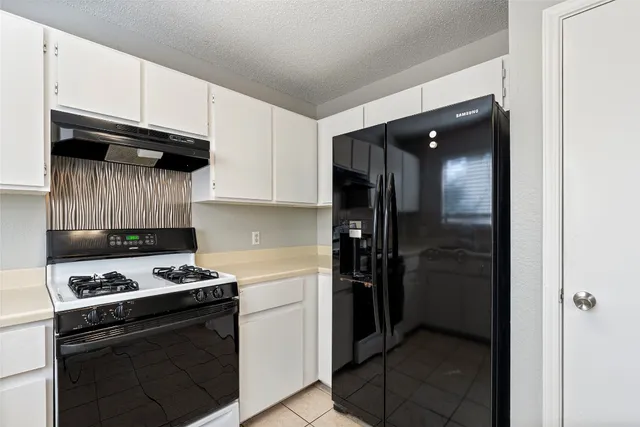 a kitchen with stainless steel appliances granite countertop a refrigerator and a stove