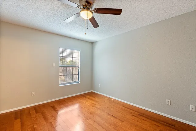 an empty room with a window and a fan