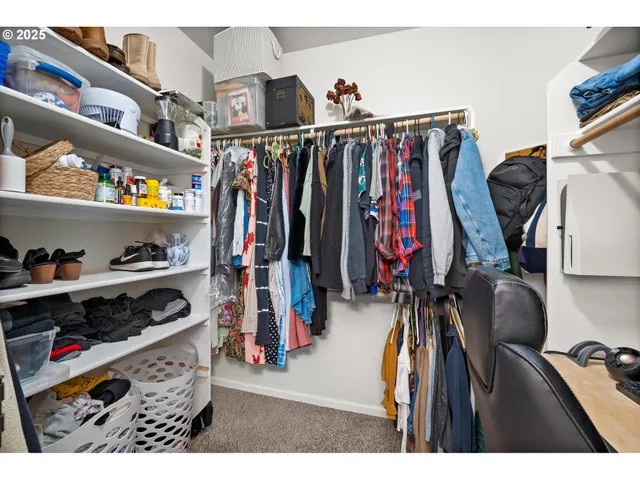 a view of walk in closet with clothes and shoes