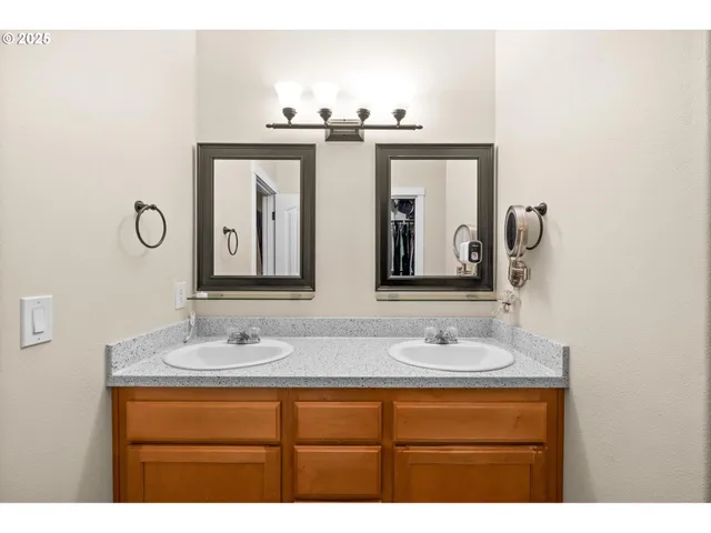 a bathroom with double vanity sinks and a mirror