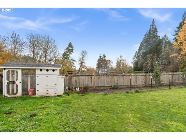 a view of a yard with wooden fence