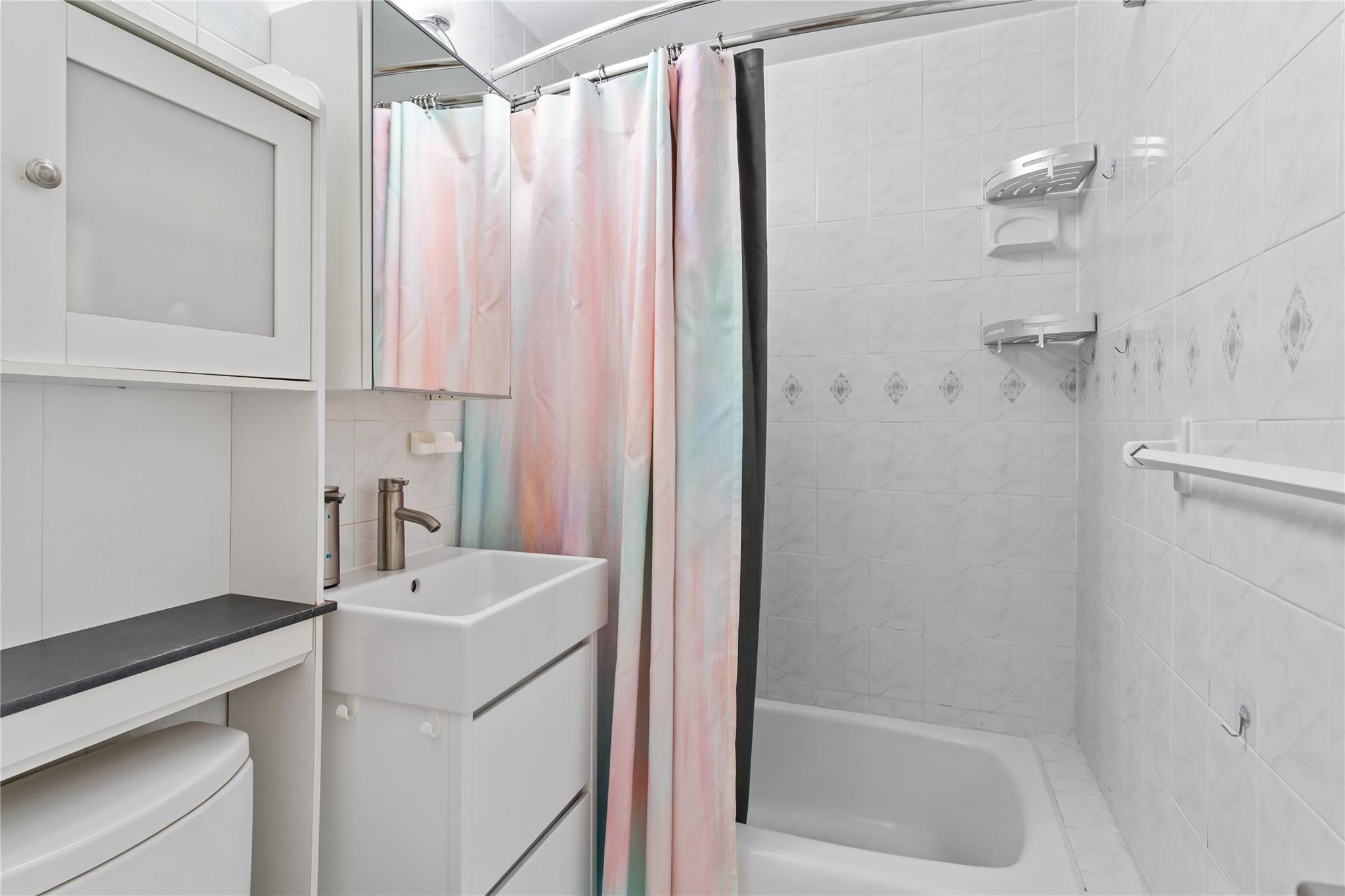 3103 Fairfield Avenue, Unit 5D Bronx, NY 10463 - Photo 8 of 13 a bathroom with a sink a mirror and a shower