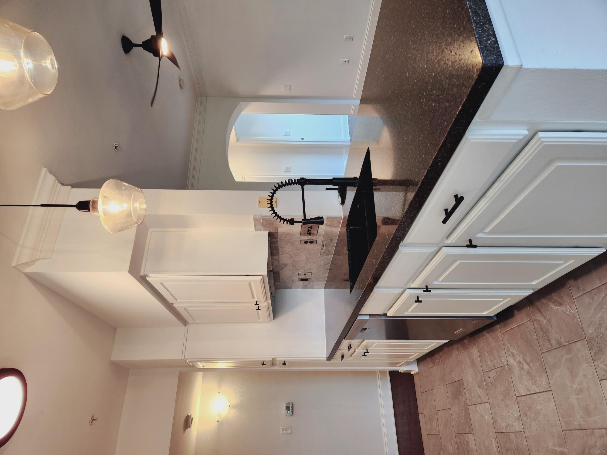 7701 Rialto Boulevard, Unit 833 Austin, TX 78735 - Photo 9 of 24 a kitchen with granite countertop a sink a stove and cabinets